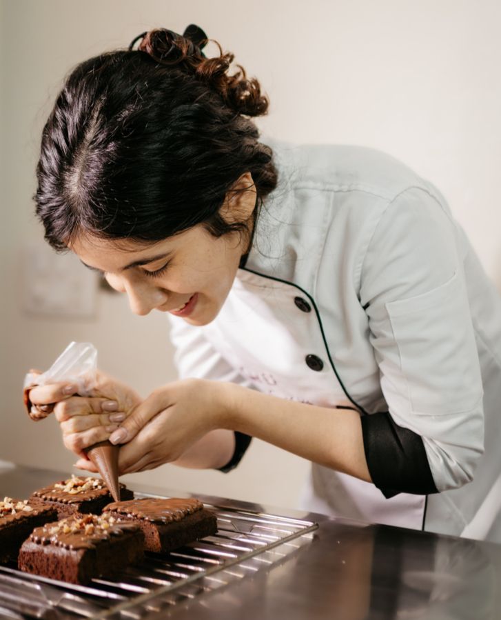 Chef Sneha Singhi, owner of Claro Bakehouse, piping ganache onto fresh brownies