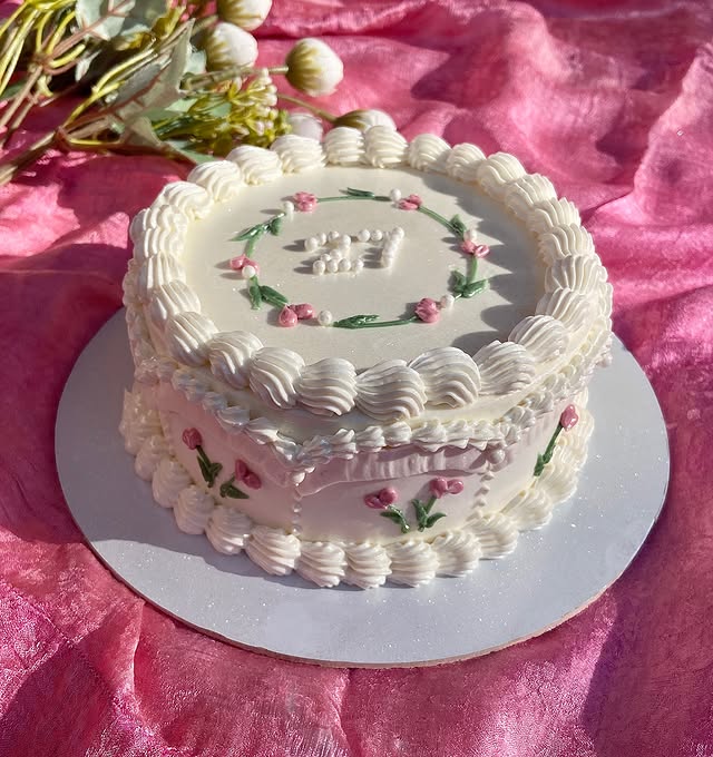 White lambeth-style cake with a pink floral wreath, made for a 27th birthday